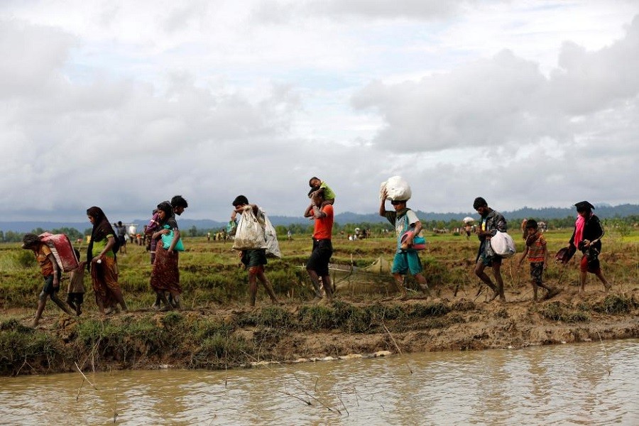 A group of Rohingya refugee people walk towards Bangladesh after crossing the Bangladesh-Myanmar border in Teknaf, Bangladesh. Reuters