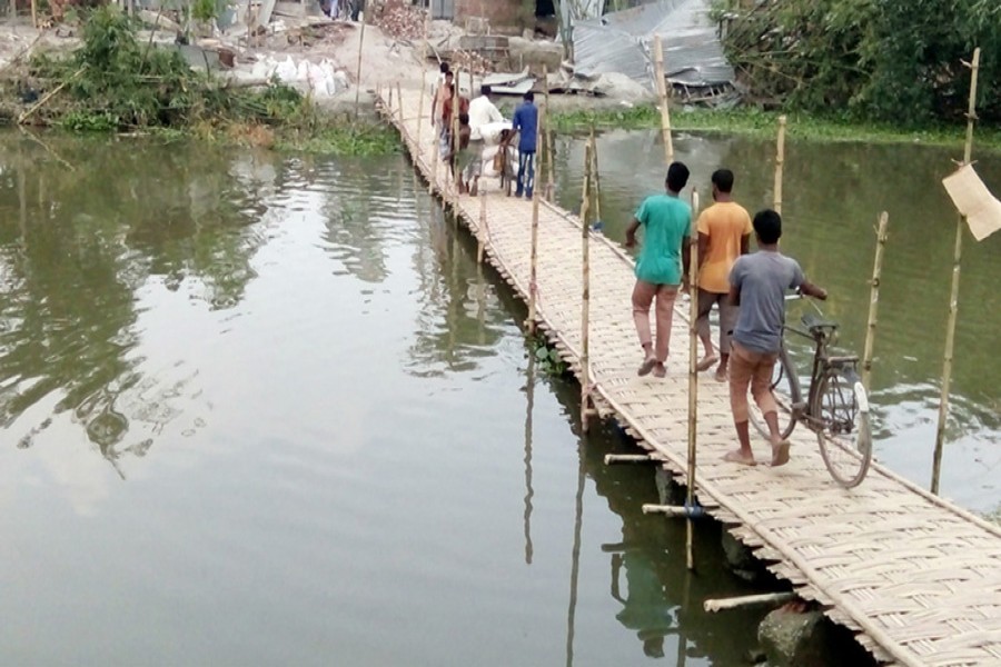 Local people built a bamboo bridge on the broken part of a road in Alemarbazar area under Gangachara upazila of Rangpur. 	— FE Photo