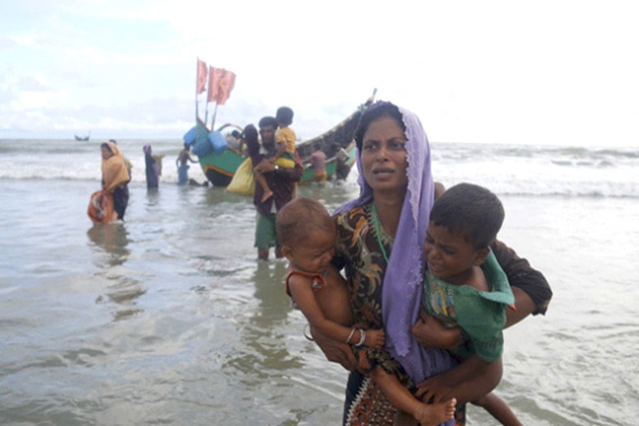 Rohingya people alight from a boat as they arrive at Shahparir Dip in Teknaf, Bangladesh. — IPS