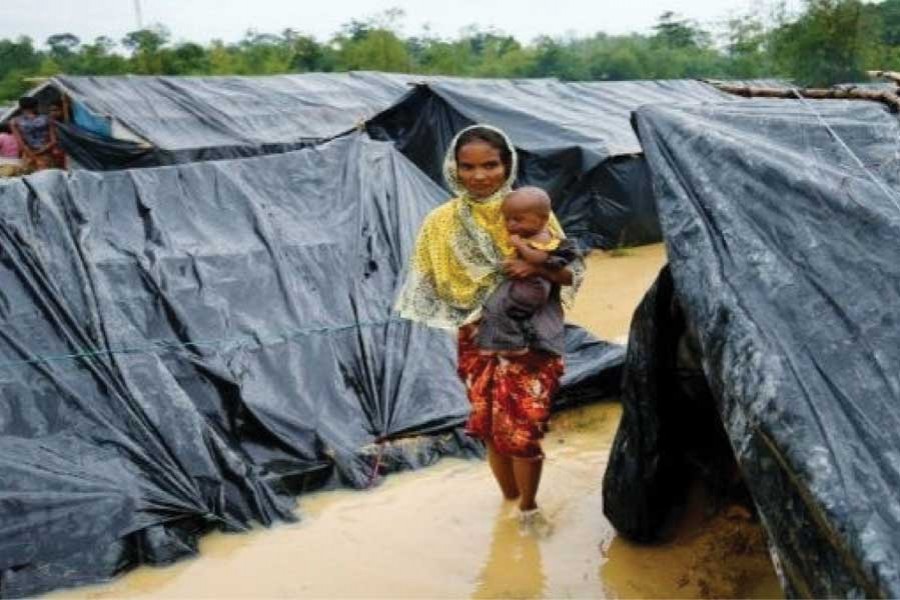 A Rohingya refugee woman and her child walk in floodwaters near makeshift shelters after heavy rains in Cox's Bazar in the second week of September, 2017.  	—Photo: Reuters
