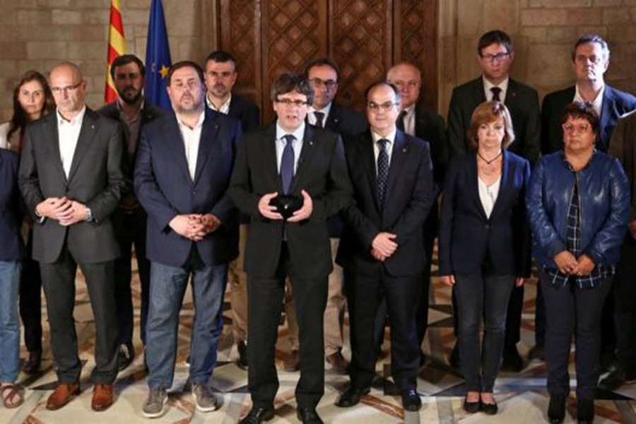 Catalan leader Carles Puigdemont was flanked by members of his government as he made his statement. Reuters