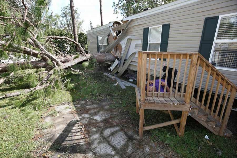A resident of a mobile home park lies near a home that was destroyed by a falling tree in the wake of Hurricane Irma in Kissimmee, Florida, US September 12. 	— Reuters