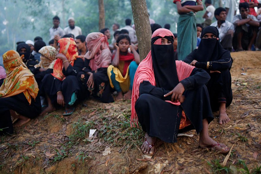 Rohingya refugees wait to receive humanitarian aid at Kutupalong refugee camp near Cox's Bazar on Tuesday. - Reuters photo
