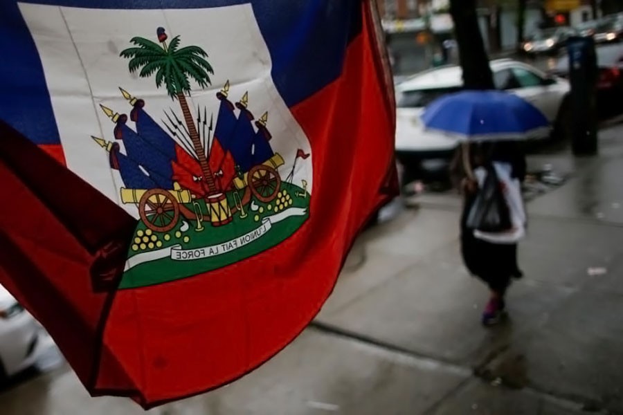A Flag from Haiti is pictured in a local store as a woman walks under rain at the neighborhood of Brooklyn in New York, US May 13, 2017 (Reuters photo)