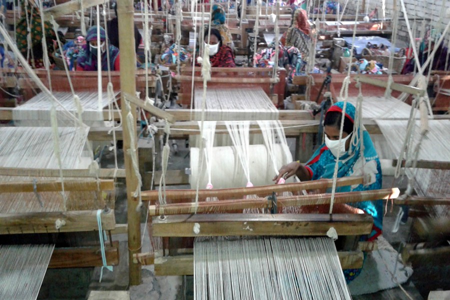 RANGPUR: Johra Begum makes doormat at a factory in Tajhat area of Rangpur city on Monday.  	— FE Photo
