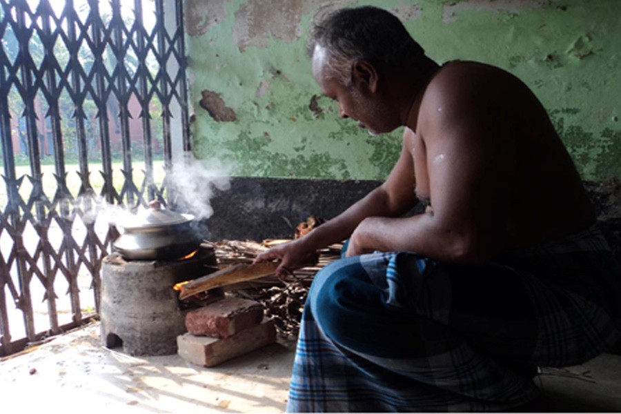 A man is seen cooking food using ecological hearth at Dupchanchia Sarderpara area in the district, photo: FE