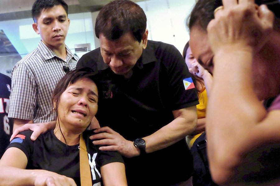 President Rodrigo Duterte comforts a family member of a fire victim in Davao city in Philippines on Sunday. -Reuters Photo