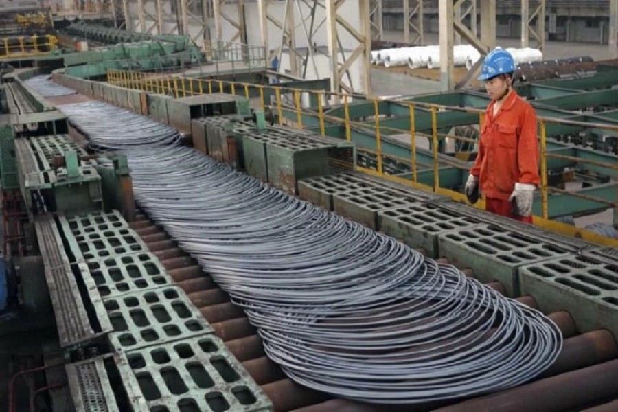 A labourer looks at steel coils next to a production line of Dongbei Special Steel Group Co., Ltd., in Dalian, Liaoning province September 27, 2013. Reuters/File Photo