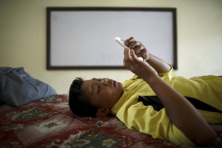 In file photo,  A boy uses a phone inside a classroom of a Tibetan monastery in Kathmandu, Nepal . - Reuters