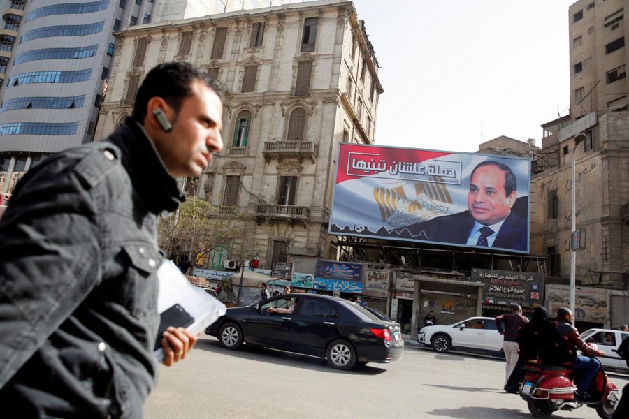 People walk by a poster of Egypt's President Abdel Fattah al-Sisi from the campaign titled “Alashan Tabneeha” (So You Can Build It), for the upcoming presidential election in Cairo, Egypt, January 22, 2018. (REUTERS)