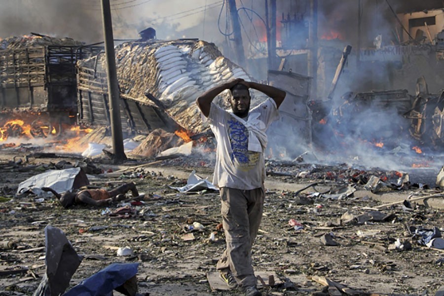 A Somali gestures as he walks past a dead body, left, and destroyed buildings at the scene of a blast in the capital Mogadishu, Somalia on Sunday. (AP photo used for representation)