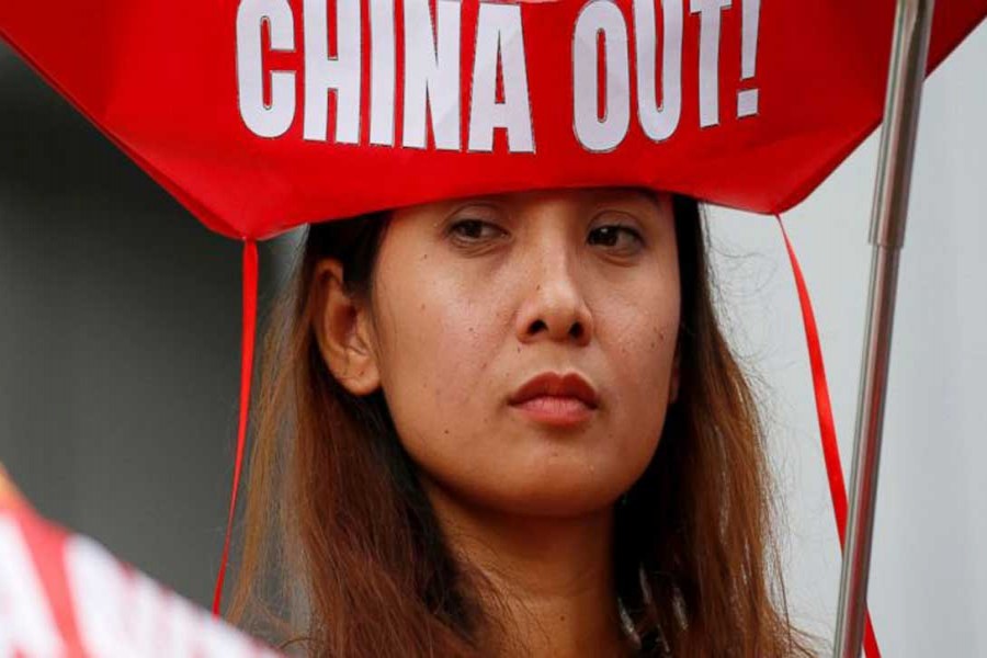 A protester holds a flag during a rally at the Chinese Consulate to protest China's alleged continued militarisation of the disputed islands in the South China Sea known as Spratlys Saturday, Feb. 10, 2018 in the financial district of Makati city east of Manila, Philippines.  - AP