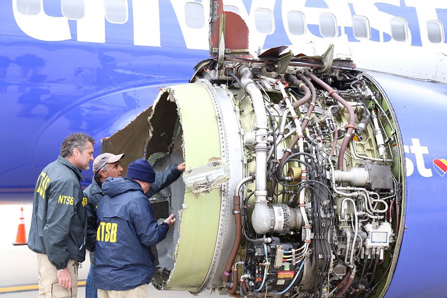 Investigators examine the damaged engine of Southwest Airlines flight WN1380 which was en route to Dallas from New York - Reuters photo