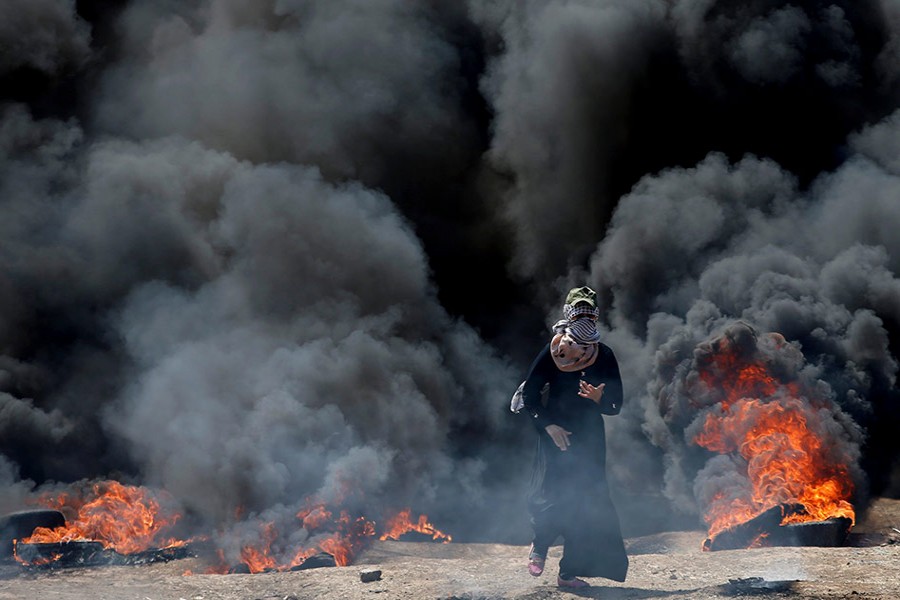 A female Palestinian demonstrator gestures during a protest against US embassy move to Jerusalem and ahead of the 70th anniversary of Nakba, at the Israel-Gaza border, east of Gaza City on Monday. -Reuters Photo