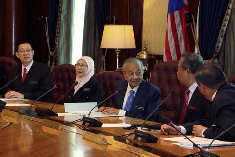 In this photo released by Malaysia Minister of Economic Affairs Azmin Ali’s Office, Malaysian Prime Minister Mahathir Mohamad (third from right) chairs the first cabinet meeting with the new Malaysia cabinet members in Putrajaya, Malaysia on Wednesday, May 23, 2018.   Photo Credit: AP