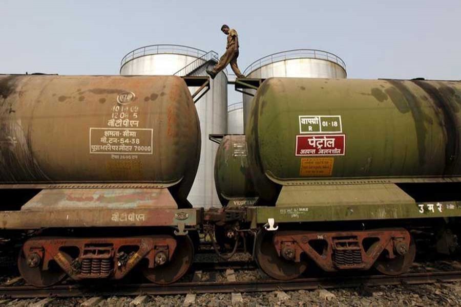 A worker walks atop a tanker wagon to check the freight level at an oil terminal on the outskirts of Kolkata, November 27, 2013. Reuters/Files