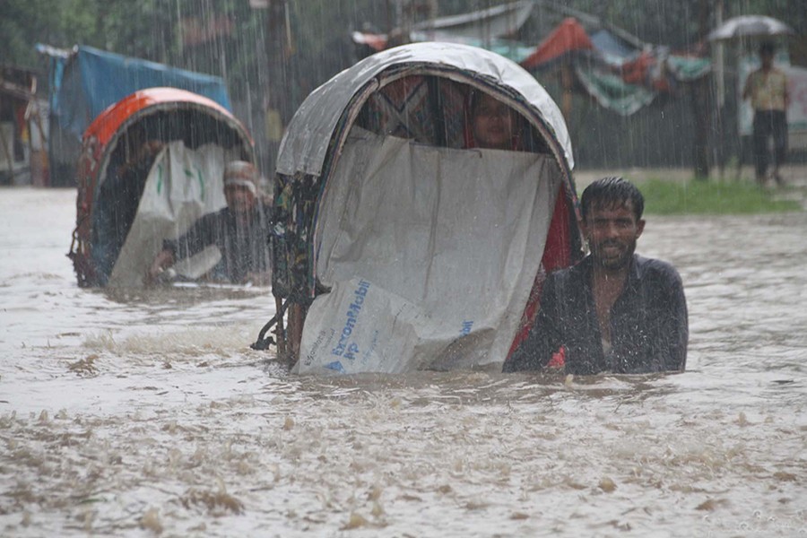 Rickshaw pullers seen struggling to get ahead in the submerged Sholoshahar area of Chittagong — Focus Bangla file photo