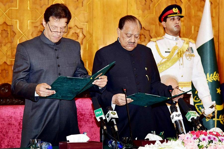 Cricketer-turned-politician Imran Khan (L) taking the oath of the Prime Minister from President Mamnoon Hussain in Islamabad on Saturday. -Reuters Photo