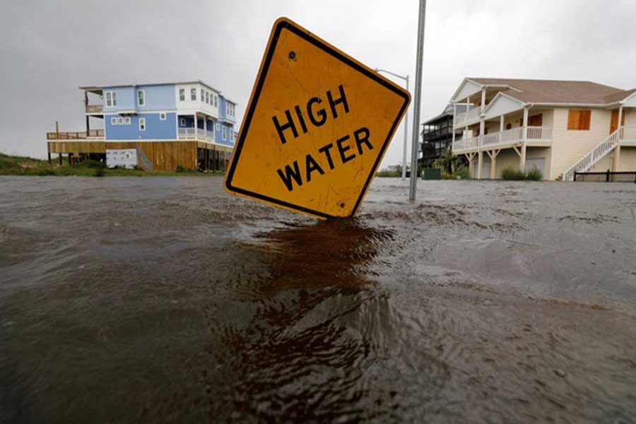 Flood waters lap at a high water warning sign that was partially pushed over by Hurricane Florence on Oak Island, North Carolina, US, September15, 2018. Reuters