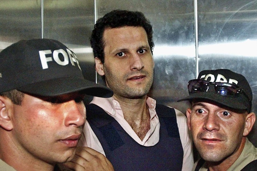 Lebanese citizen Assad Ahmad Barakat, who was then facing tax evasion charges, is escorted by police to a courthouse in Asuncion, Paraguay, on November 17, 2003 - AP file Photo