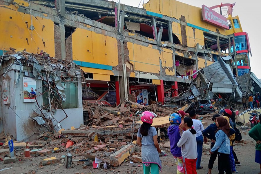 Residents stand in front of a damaged shopping mall after an earthquake hit Palu, Sulawesi Island, Indonesia on Friday — Reuters photo