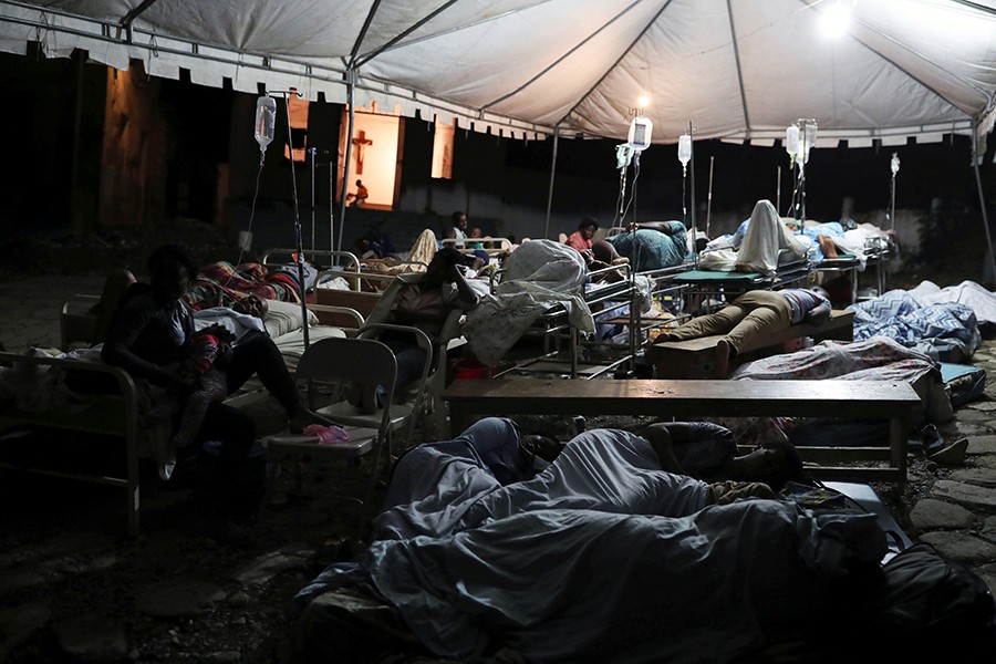 People injured in an earthquake that hit northern Haiti late on Saturday, sleep in a tent, in Port-de-Paix — Reuters photo