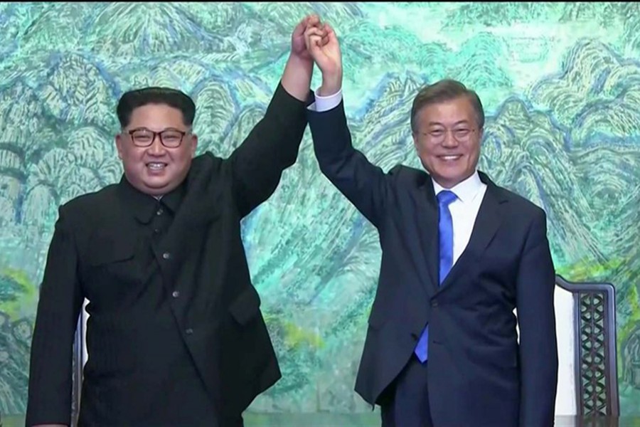 North Korean leader Kim Jong-un (L) and South Korean President Moon Jae-in raise their hands in unity after signing agreements during the inter-Korean summit at Panmunjom on April 27 last. Photo: Reuters TV frame grab