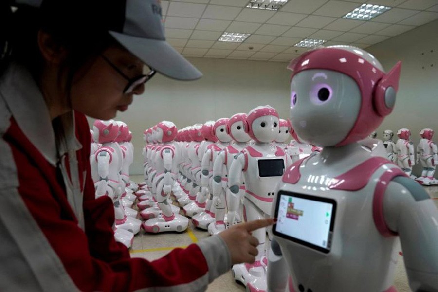 A worker puts finishing touches to an iPal social robot, designed by AvatarMind, at an assembly plant in Suzhou, Jiangsu province, China, July 4, 2018. Reuters/File Photo