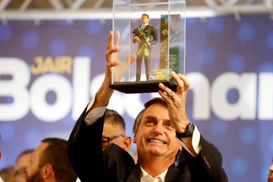 Federal deputy Jair Bolsonaro, a candidate for Brazil's presidential elections, shows a doll of himself during a rally in Curitiba, Brazil March 29, 2018. Reuters/File photo