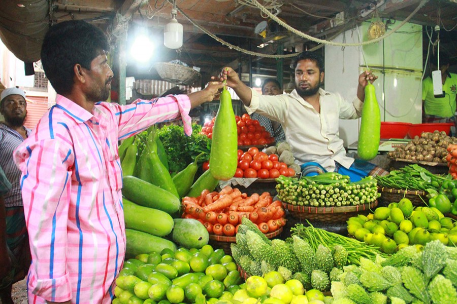 A vegetable vendor seen selling gourd to a customer at Kaptan Bazar in Dhaka's Gulistan in this undated Focus Bangla photo