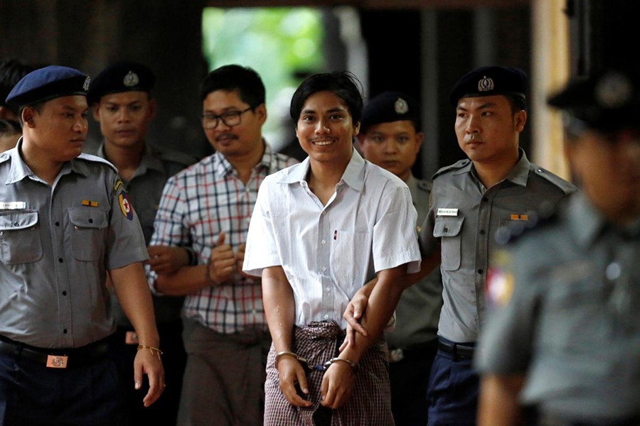 Police escort jailed Reuters journalists Kyaw Soe Oo (White shirt) and Wa Lone as they arrive before a court hearing in Yangon, Myanmar — Reuters/File