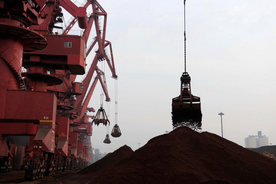 Cranes unload iron ore from a ship at a port in Rizhao, Shandong province, February 7, 2015. Reuters/File Photo