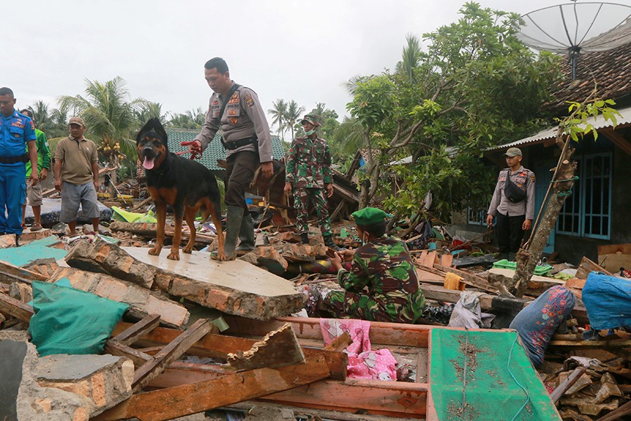 Rescue workers use a dog to search victims among debris after a tsunami hit Sunda Strait at Rajabasa in South Lampung, Indonesia on December 25, 2018 — Reuters photo