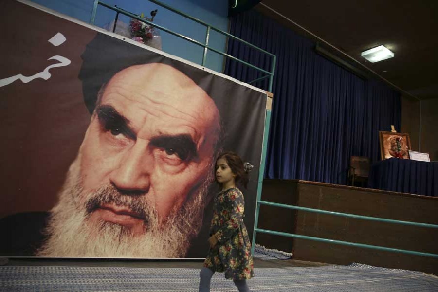 In this Tuesday, Jan. 22, 2019, photo, a girl walks past a poster of Ayatollah Ruhollah Khomeini, at a mosque where he made speeches, in northern Tehran, Iran.  – AP photo
