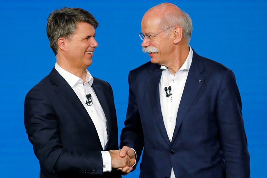 Harald Kruger, CEO and Chairman of the Board of Management of BMW AG and Dieter Zetsche, CEO of Daimler AG, shaking hands at a news conference to present plans for combining the companies' car-sharing businesses, in Berlin, Germany on Friday. -Reuters photo