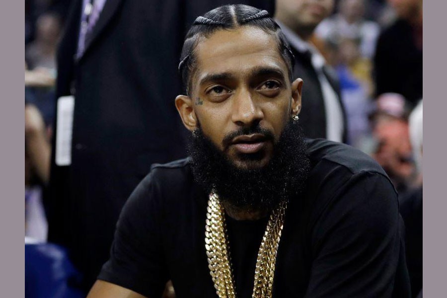 In this March 29, 2018, file photo, rapper Nipsey Hussle watches an NBA basketball game. AP Photo/Marcio Jose Sanchez, File