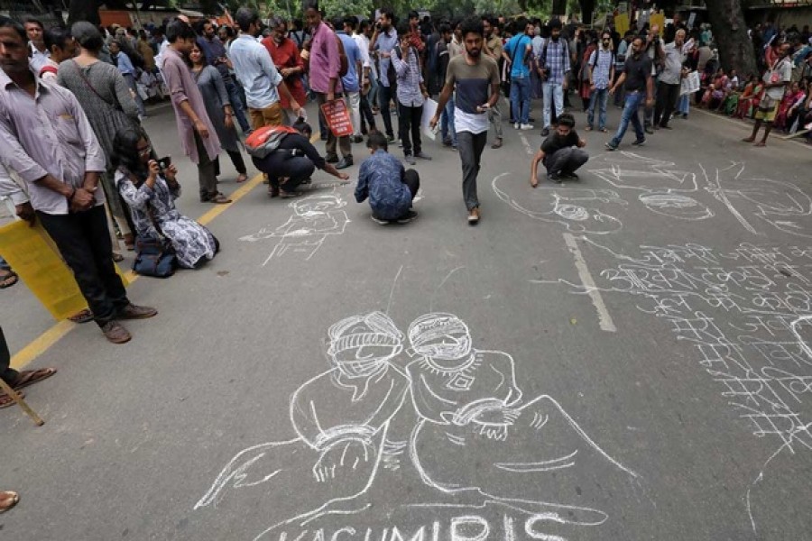 People draw and write messages on a road during a protest against the scrapping of the special constitutional status for Kashmir by the government, in New Delhi, India, Aug 7, 2019. REUTERS