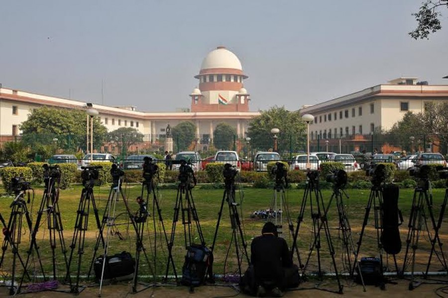A television journalist sets his camera inside the premises of the Supreme Court in New Delhi, February 18, 2014. Reuters/File Photo