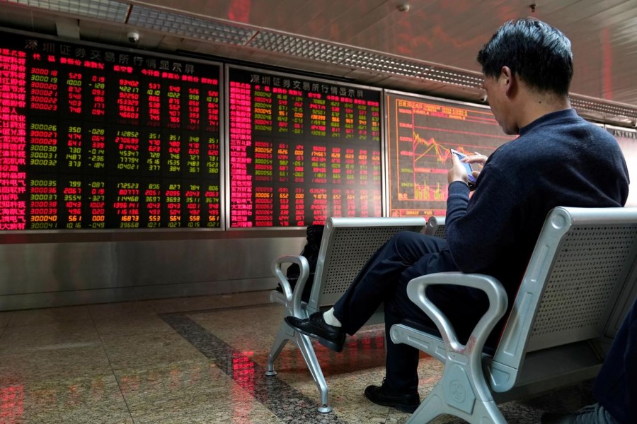 An investor sits next to a stock quotation board at a brokerage office in Beijing, China, January 03, 2020. Reuters