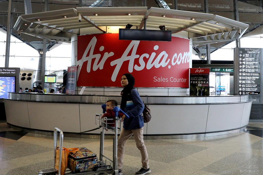 A woman walks past an AirAsia counter at Kuala Lumpur International Airport in Sepang, Malaysia on July 22, 2019 — Reuters/Files