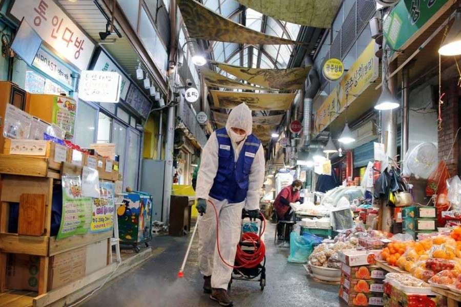 An employee from a disinfection service company sanitizes at a traditional market in Seoul, South Korea, February 7, 2020.  REUTERS/Heo Ran