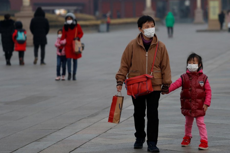 People wearing face masks walk at the Tiananmen Gate, as the country is hit by an outbreak of the new coronavirus, in Beijing, China January 27, 2020. REUTERS/Carlos Garcia Rawlins