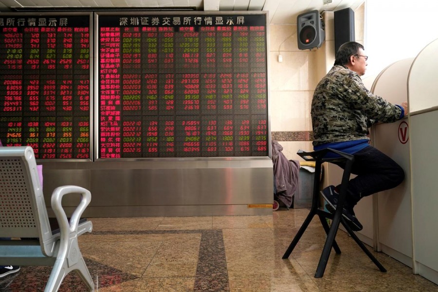 An investor sits next to a stock quotation board at a brokerage office in Beijing, China, January 3, 2020. Reuters