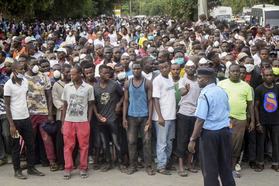 Kenyan police holding back ferry passengers after new measures aimed at halting the spread of the new coronavirus instead caused a crowd to form outside the ferry in Mombasa, Kenya on Friday. -AP Photo