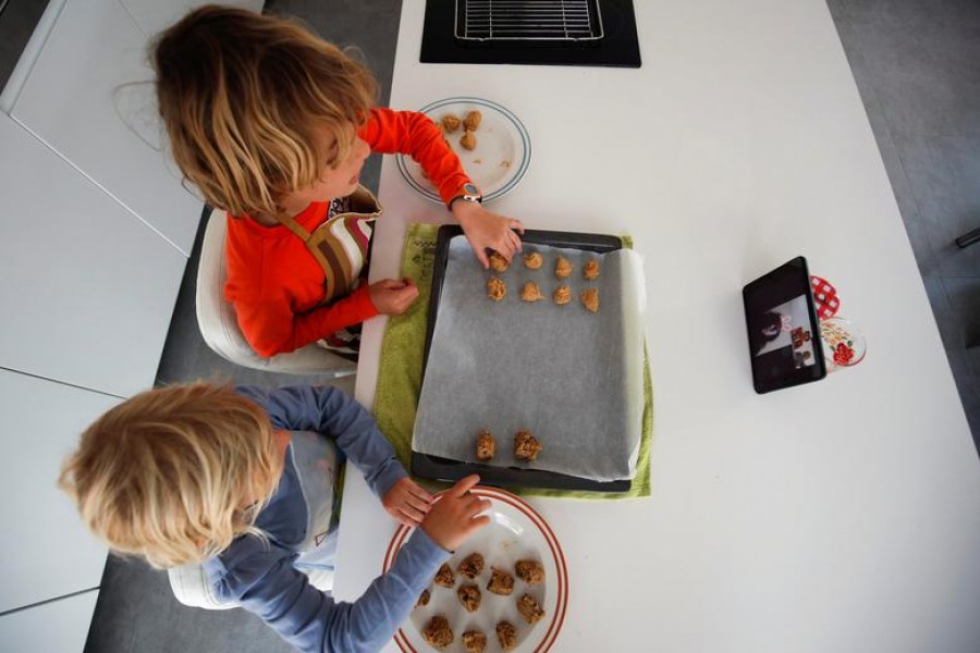 Children make cookies following the instructions of their grandparents via Facebook's Messenger video-chat on an iPad during the coronavirus disease (COVID-19) outbreak in El Masnou, north of Barcelona, Spain, April 8, 2020. REUTERS/Albert Gea