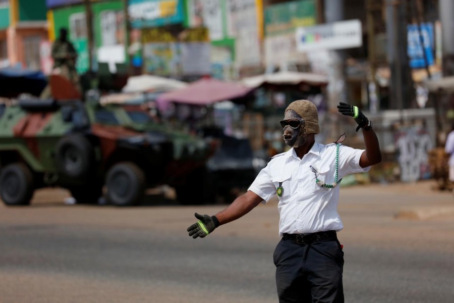 FILE PHOTO: A security personnel from town council wears a face mask while he controls traffic, as Ghana enforces partial lockdown in the cities of Accra and Kumasi to slow the spread of the coronavirus disease (COVID-19) in Madina neighborhood of Accra, Ghana, March 31, 2020. REUTERS/Francis Kokoroko