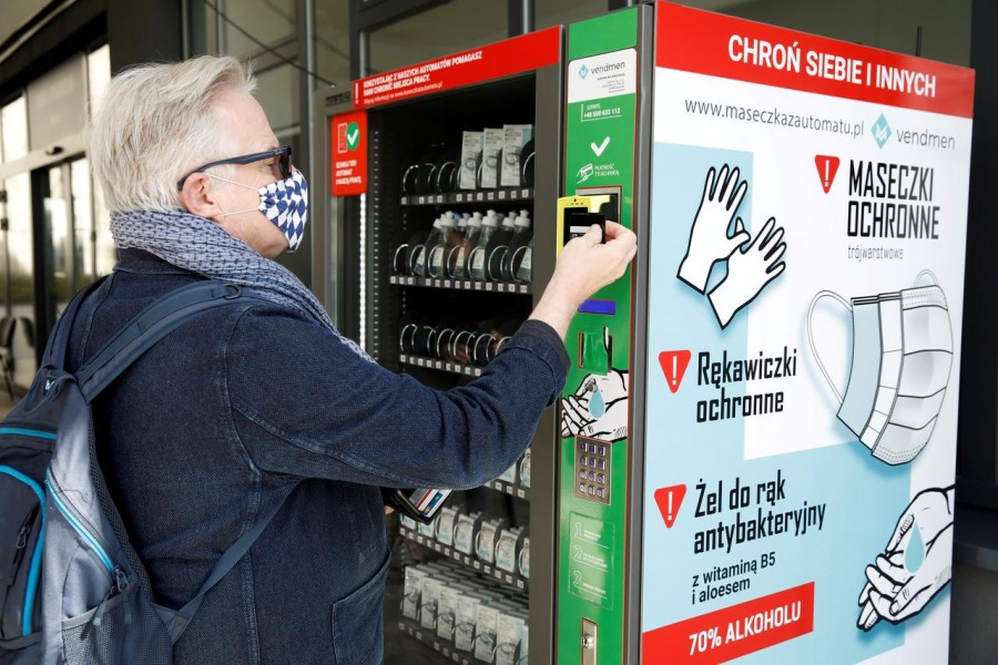 A man uses a vending machine for face masks, gloves, and sanitiser during the coronavirus disease (COVID-19) outbreak, in Warsaw, Poland on April 10, 2020 — Reuters/Files