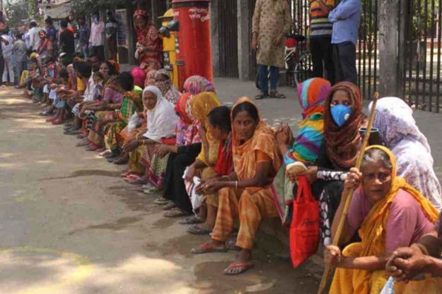 Low-income people were seen waiting at different intersections of the city in the hope of getting food and relief materials. (UNB file photo)