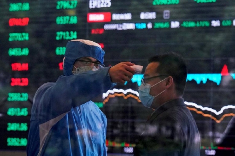 A worker wearing a protective suit takes body temperature measurement of a man inside the Shanghai Stock Exchange building, as the country is hit by the coronavirus outbreak, at the Pudong financial district in Shanghai, China, February 28, 2020 — Reuters/Files