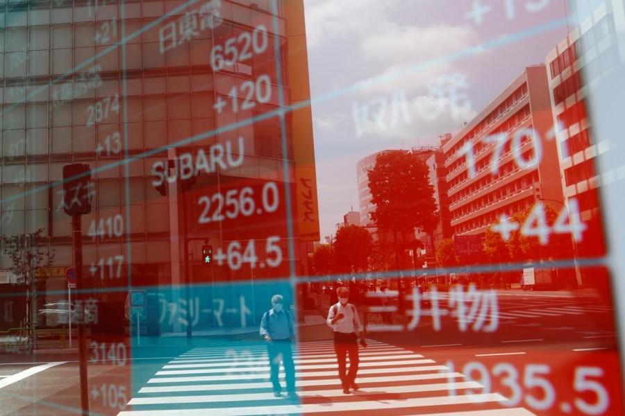 People wearing protective masks, following the coronavirus disease (Covid-19) outbreak, are reflected on a screen showing stock prices outside a brokerage in Tokyo, Japan on August 31, 2020 — Reuters/Files